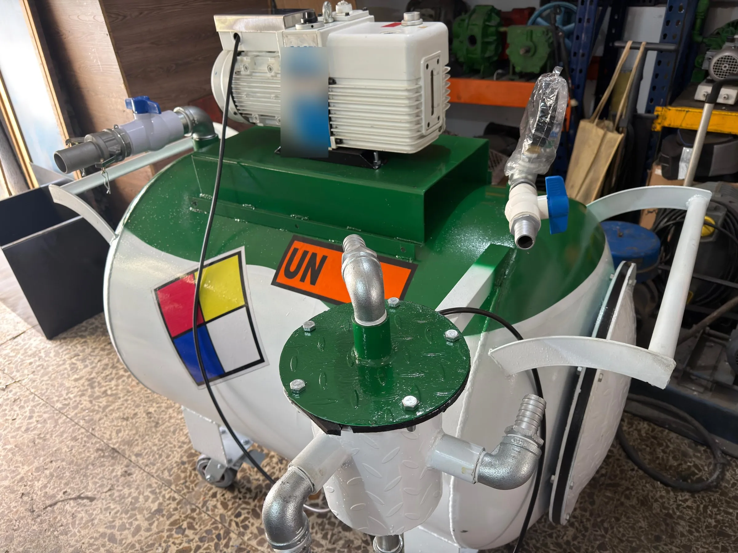 Equipo compacto sobre ruedas con tanque de vacío blanco y verde y bomba de vacío en la parte superior