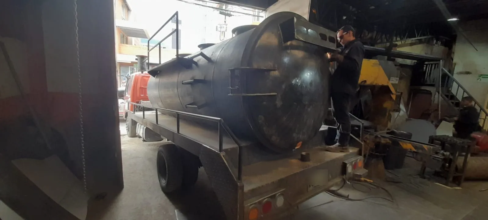 Soldador trabajando en la tapa de un tanque de vacío montado sobre camión